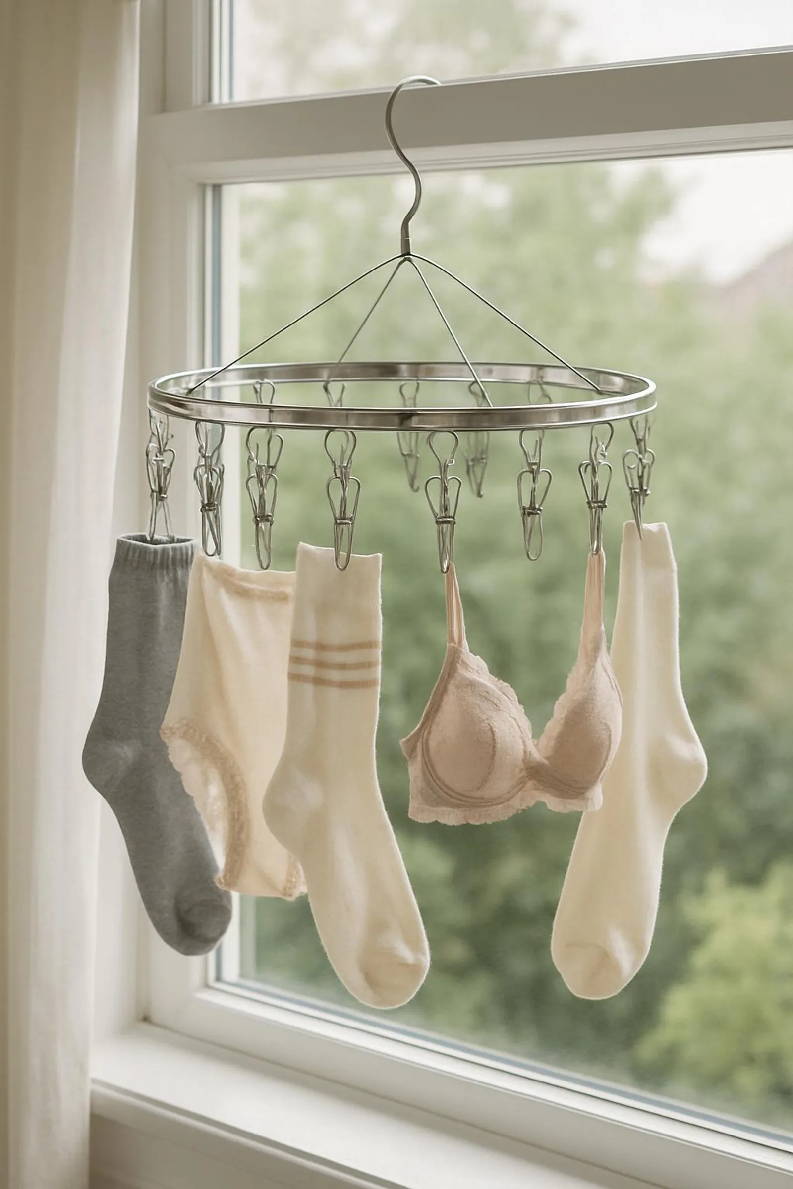 Circular clip hanger holding socks and delicates, hanging by a window