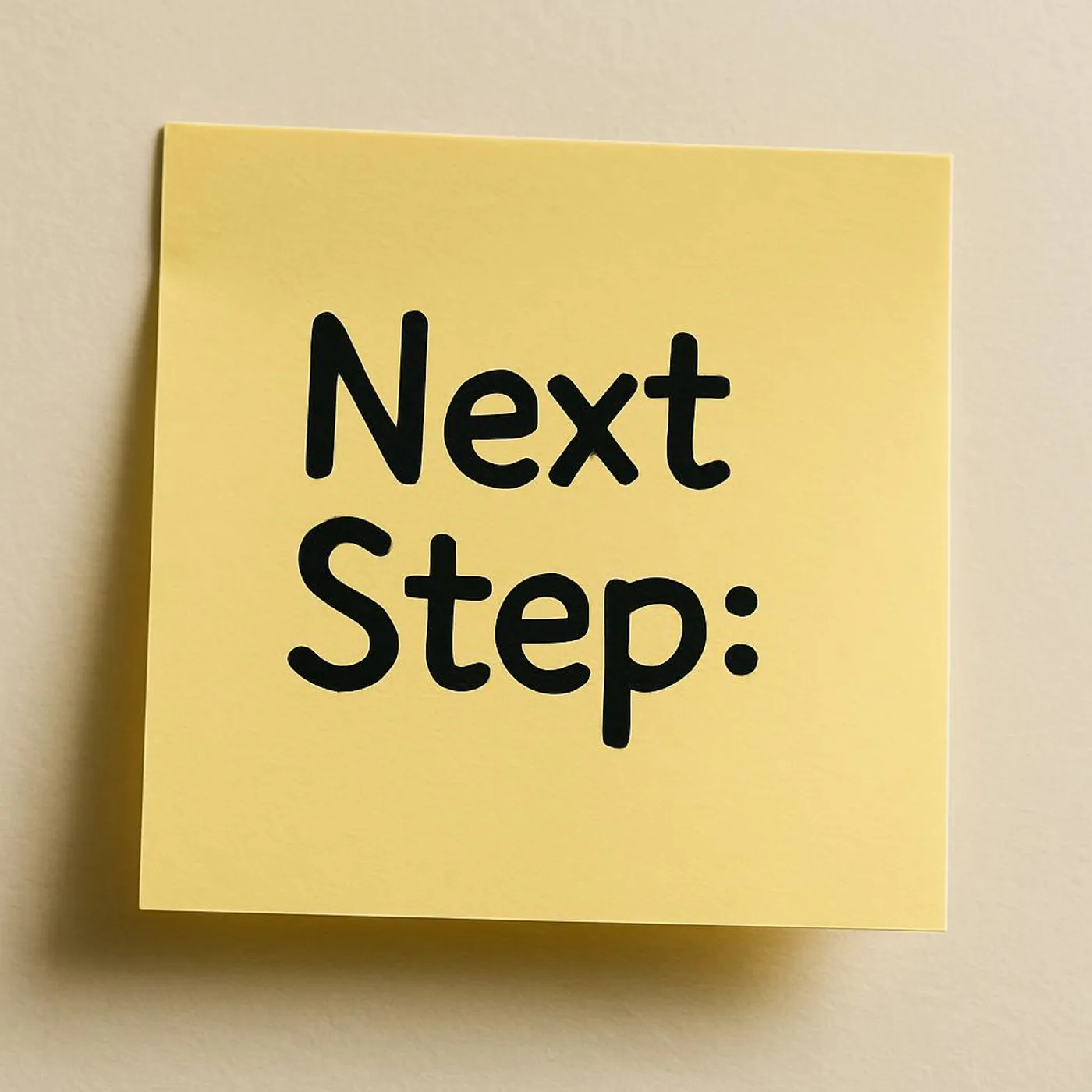 Close-up of a sticky note with a clear next step written on it