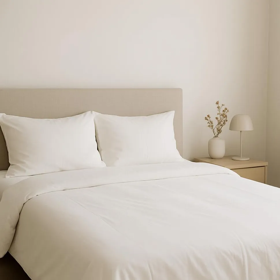 Made bed with white sheets and minimal decor