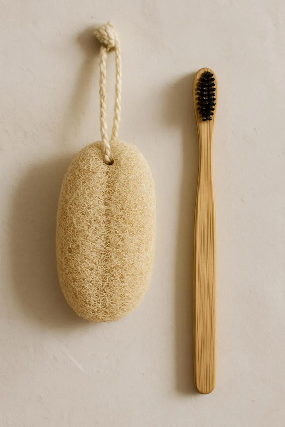 Natural loofah hanging beside bamboo toothbrush